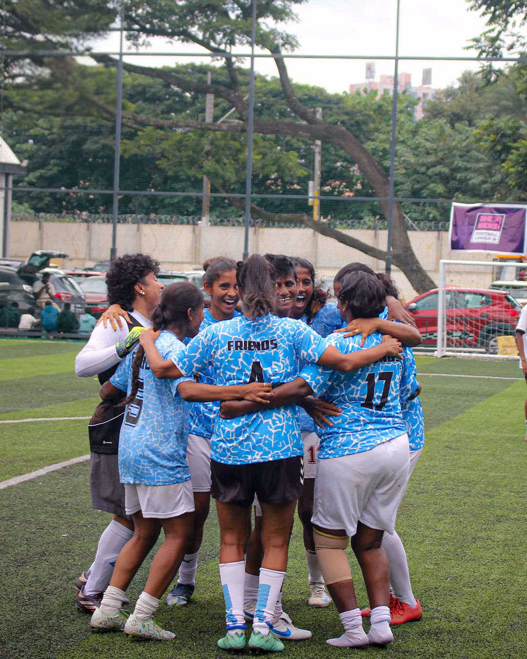 She Kicks Football League players celebrating on the pitch